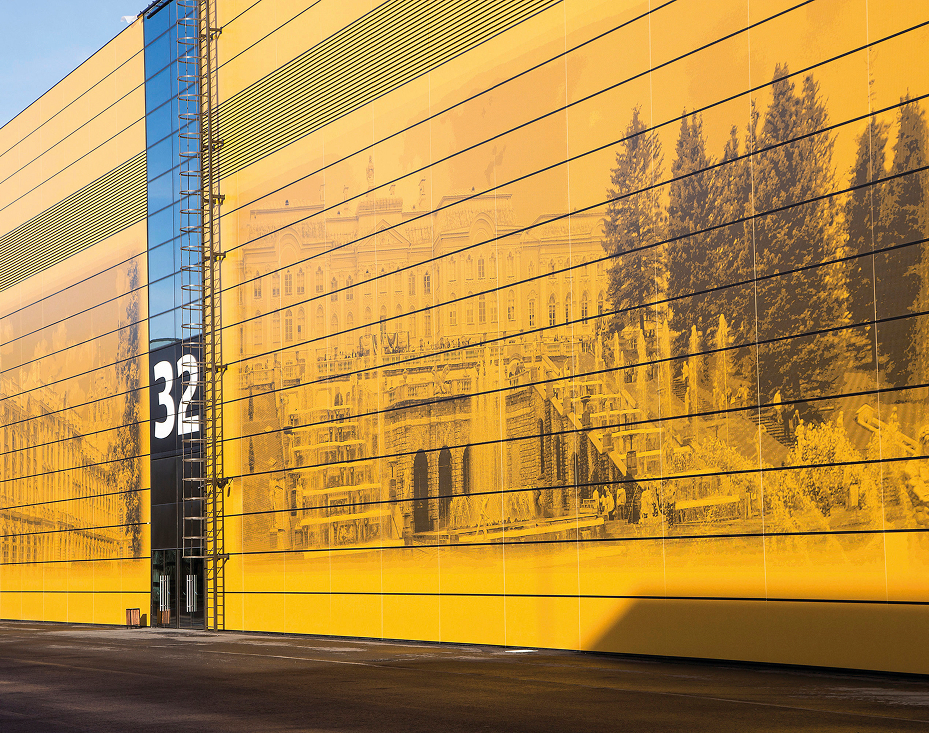Outdoor facade with large yellow custom ceramic slab featuring a landscape image